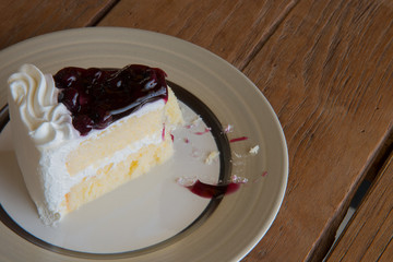 A piece of delicious blueberries cake on wooden background.