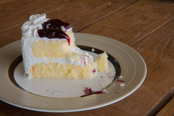 A piece of delicious blueberries cake on wooden background.