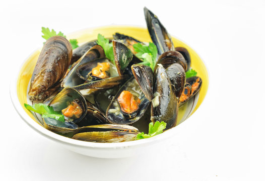 Mussel soup with fresh parsley on white background