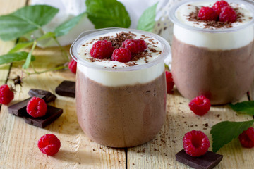 Homemade chocolate mousse with raspberries on a wooden table, se