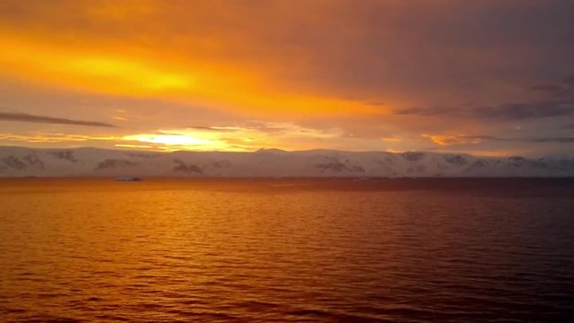 Sunrise over Brabant Island, Gerlache Strait, Antarctica. Brabant island is the second largest island in the Palmer Archipelago. Large ice-cliffs protect its coastline from the sea.