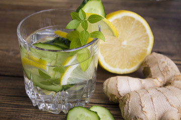 glasses of water with fruit, ginger, cucumber and a sprig of Basil