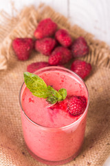 Smoothie in a glass and fresh raspberries