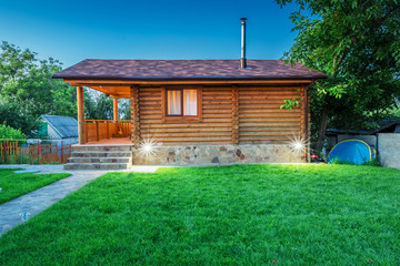 Obraz premium Wooden house with meadow in front of it
