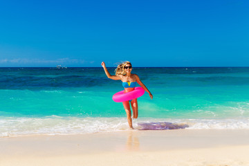 Young beautiful girl in blue bikini having fun on a tropical bea