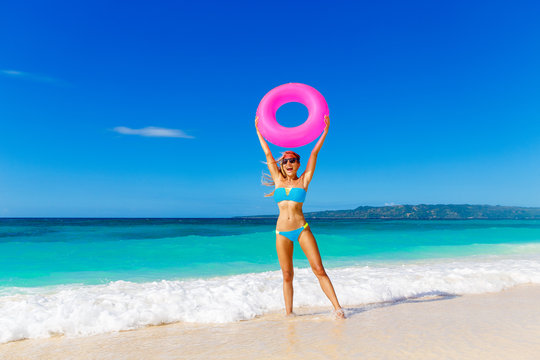Young beautiful girl in blue bikini having fun on a tropical bea