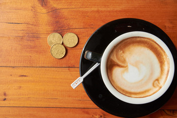 cup of coffee on the table and coins