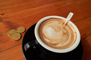 cup of coffee on the table and coins