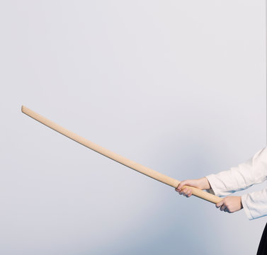 A girl in black hakama standing in fighting pose with wooden sword bokken