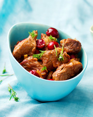 stewed pork with cherry in a blue bowl