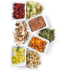 Natural flower and herb selection in ceramic bowls isolated on white