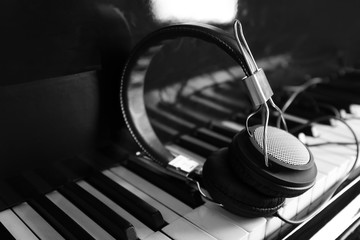 Modern headphones on piano keys