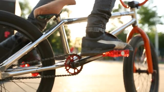 Closeup of rider feet pedaling his bmx in skatepark