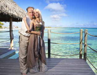 man gives a rose to the woman on the turquoise sea background...