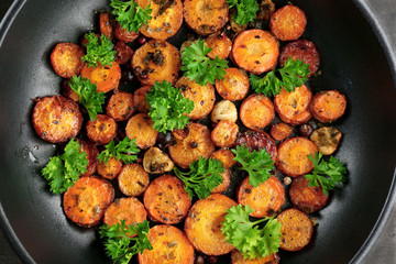 Fried sliced carrot with parsley on frying pan
