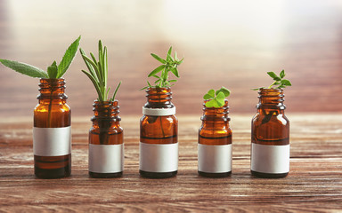 Dropper bottles and herbs on wooden table - obrazy, fototapety, plakaty