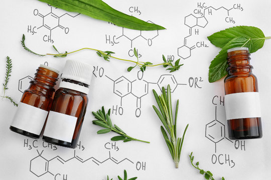 Dropper bottles and herbs on chemical formulas background
