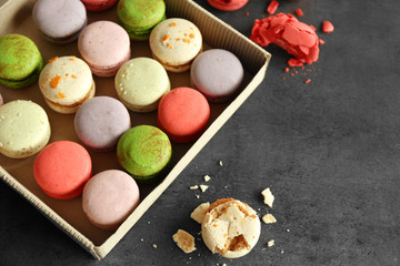 Different colorful macaroons in box on gray background