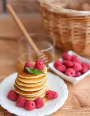 Pancakes with raspberry on wooden table