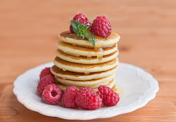 Pancakes with raspberry on wooden table
