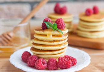 Pancakes with raspberry on wooden table