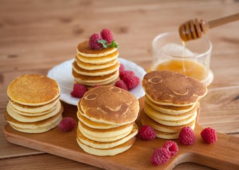 Pancakes with raspberry on wooden table. smiley face.