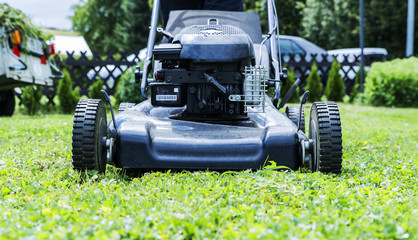 lawnmower closeup, mowing the lawn in the garden of the house