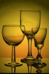 Still-life with empty glasses on colored background.