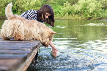 Teen Girl and Scottish Terrier dog on the bridge near the water