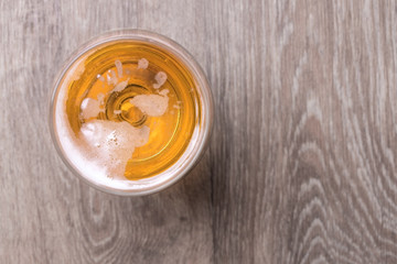 Glass of beer on wooden background.