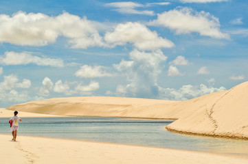 Girl walking the dunes in Lencois Maranhenses National Park, Bra