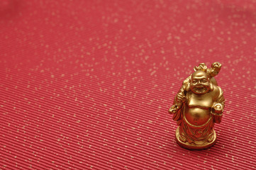 Figurine of laughing and cheerful golden Buddha
