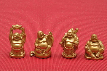 Row of Figurines of laughing and cheerful golden Buddhas
