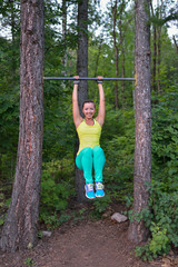 Fit woman preparing to do pull ups on horizontal bar