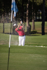 golfer hitting a sand bunker shot