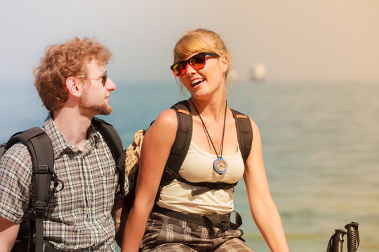 Two people tourists hiking by sea ocean.