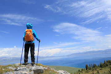 successful woman backpacker enjoy the view on mountain peak cliff