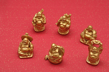 Fototapeta na wymiar Figurines of laughing and cheerful golden Buddhas