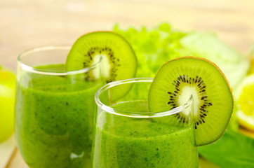 Fototapeta na wymiar Healthy green smoothie with spinach, kiwi, apples, salad and mint in glass