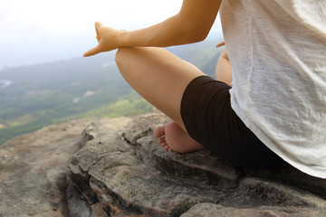 young fitness woman practice yoga at mountain peak cliff