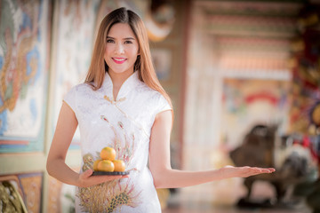 Asian Chinese woman in Traditional Chinese holding orange pay re