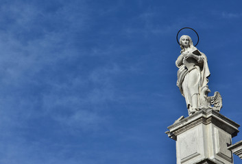 Obraz premium Statue of John the Evangelist and Apostle from baroque facade o Santa Maria Assunta jesuit church in Venice (18th century)