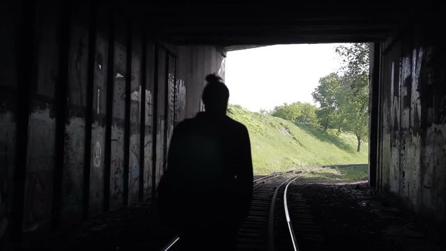 The guy goes into a tunnel on railroad tracks