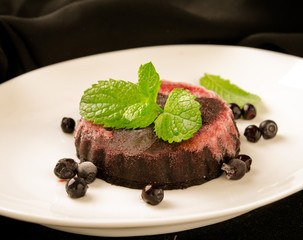 Homemade refreshing organic blueberry sorbet on a white plate with mint