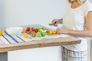 Preparing fruit salad / Women is cutting fruits for fruit salad