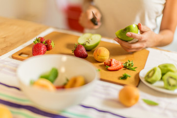 Preparing fruit salad / Women is cutting fruits for fruit salad