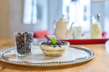 Glass with blueberries and granola / Morning food served on a table