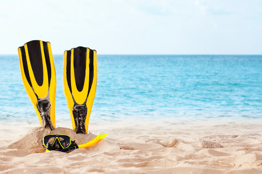 Mask with tube for snorkeling and flippers on the beach