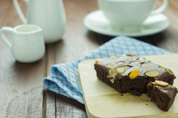 Close-up Chocolate brownie on wooden dish and cup of coffee on old wooden wood table background texture 