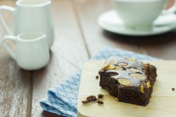 Close-up Chocolate brownie on wooden dish and cup of coffee on old wooden wood table background texture 